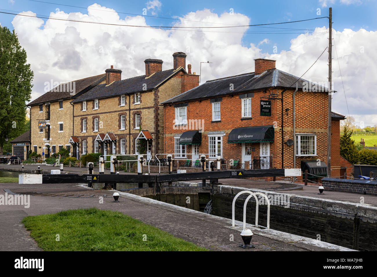 STOKE BRUERNE, NORTHAMPTONSHIRE, UK - MAY 10, 2019:  Pretty canalside cottages seen above lock on the Grand Union Canal Stock Photo