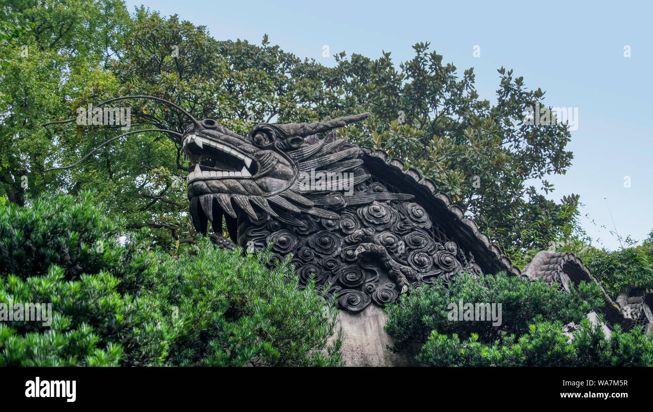 The head of a dragon or serpent - the body forms the top of the wall. Shanghai, China Stock Photo