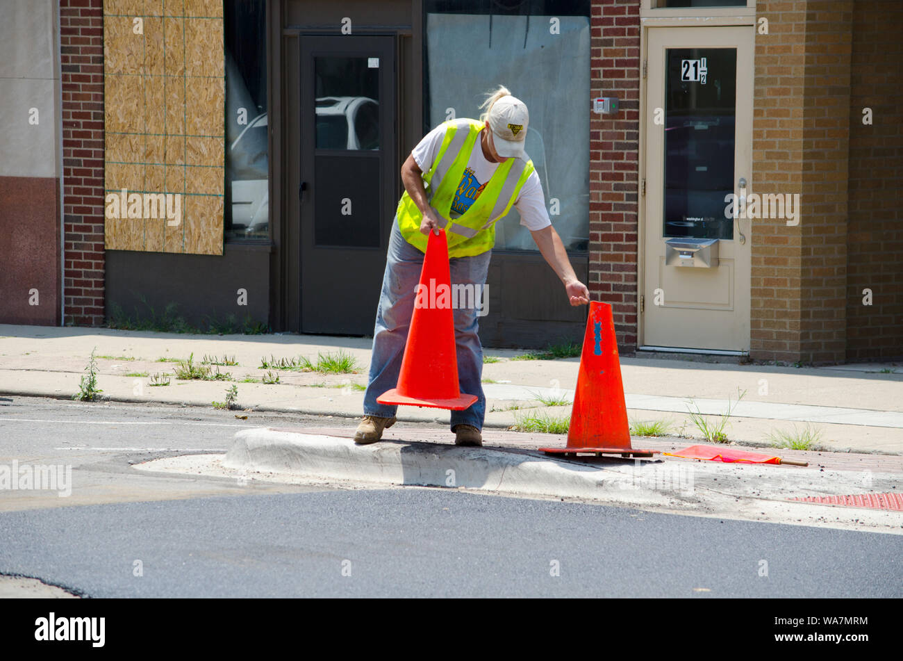 June 14 2014 Valparaiso IN USA; a woman construction worker moves safety cones over to block off an area from traffic Stock Photo