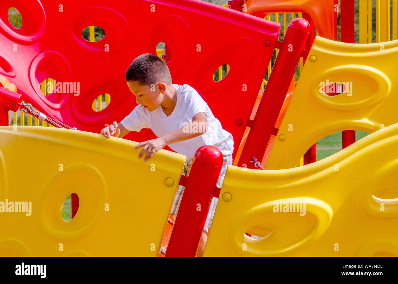 Active child climbing on a colorful on playground Stock Photo