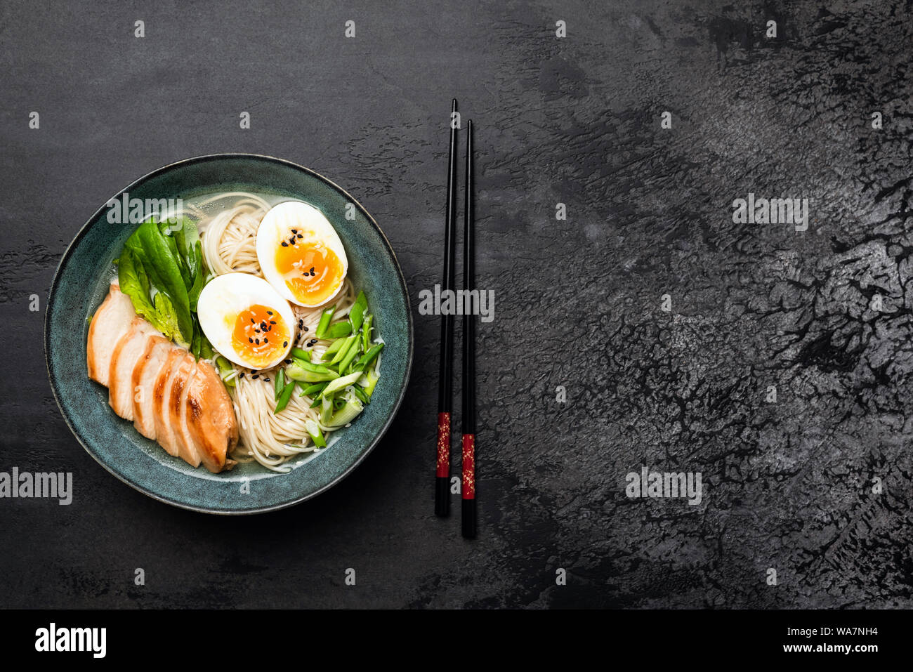 Japanese Ramen Noodle Soup With Chicken On Black Concrete Background. Table Top View And Copy Space Stock Photo
