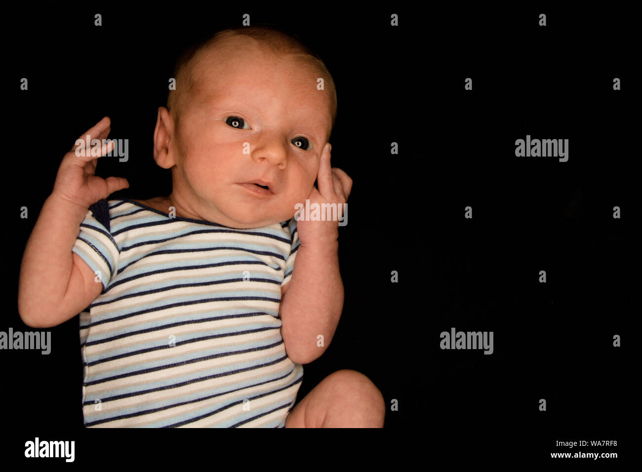 A 3 Week Old Baby Poses on a Black Background. Perfect for Memes with