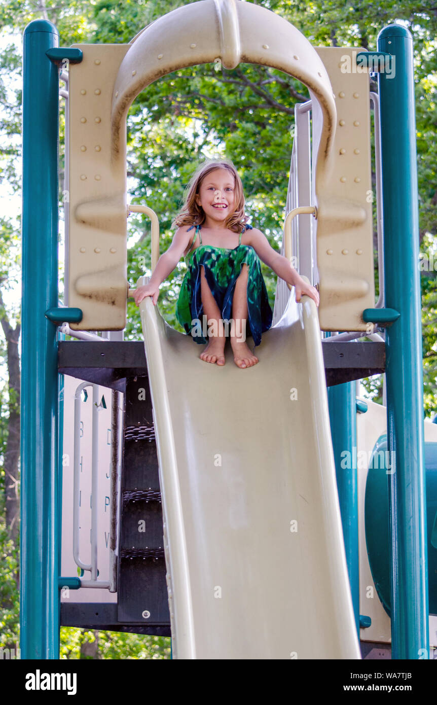 https://c8.alamy.com/comp/WA7TJB/barefoot-girl-on-a-tall-slide-playing-at-a-playground-WA7TJB.jpg