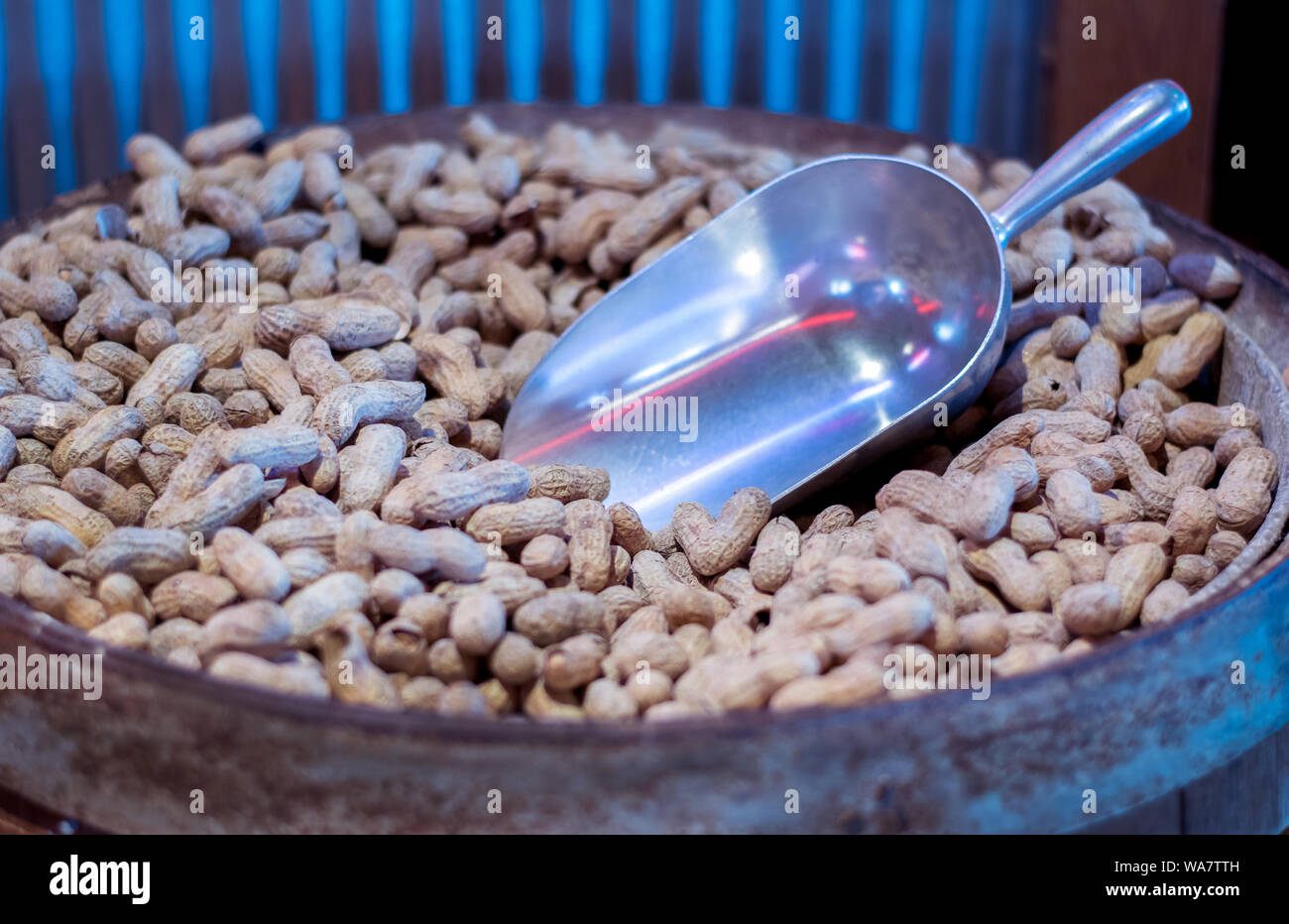 Barrel filled with roasted peanuts are scooped out and served to