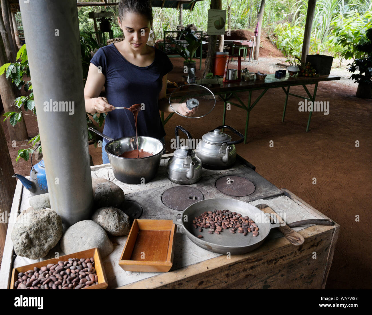 Making chocolate. Woman on Costa Rican farm making cocoa from cacao beans Stock Photo