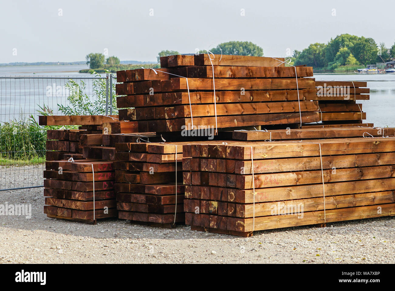 a stack of impregnated timber ready for the construction of a wooden house Stock Photo