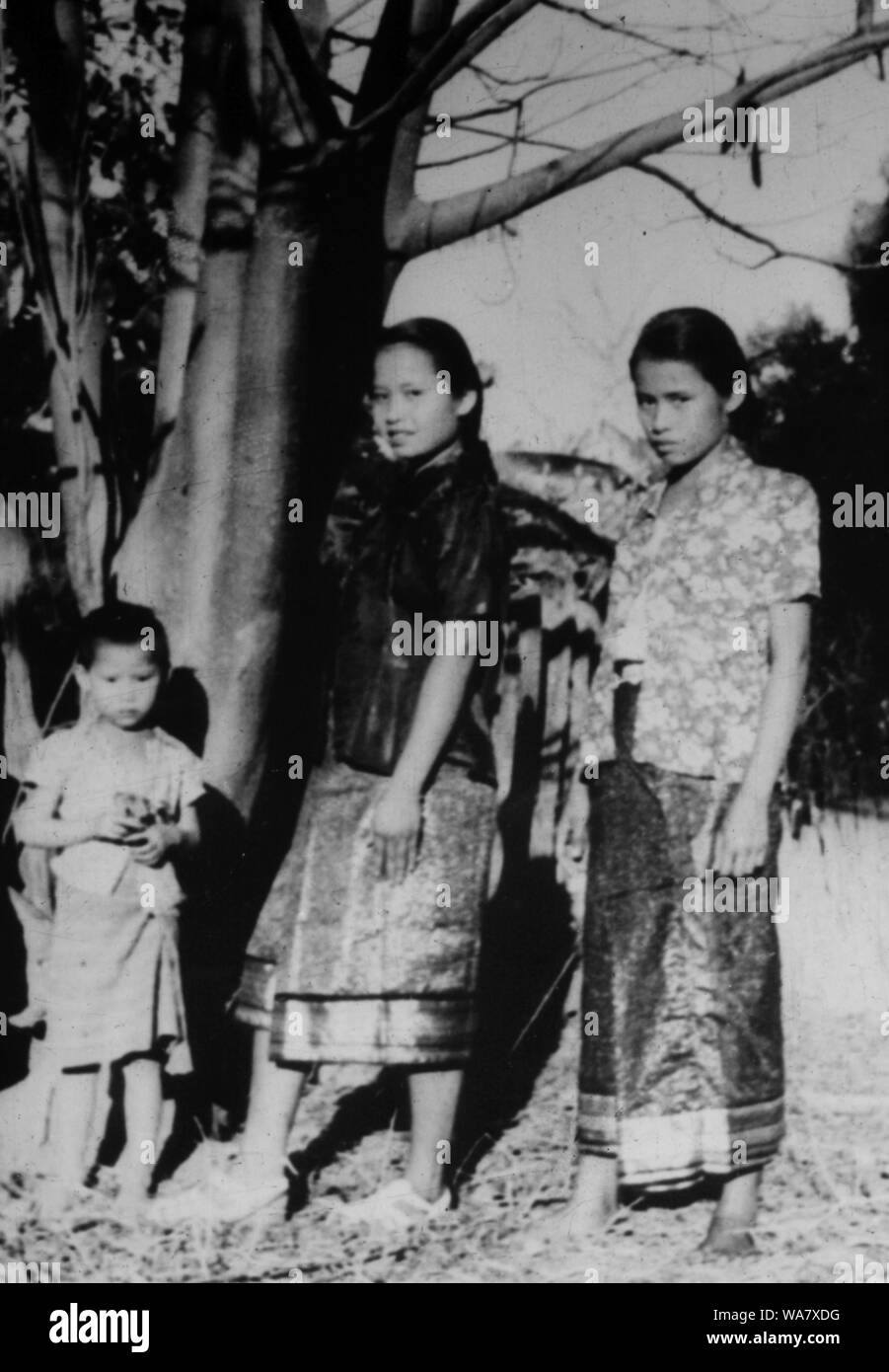 AJAXNETPHOTO. 1953-1957 (APPROX). INDO CHINA. VIETNAM. (IN-COUNTRY LOCATION UNKNOWN.) -  TWO GIRLS IN TRADITIONAL DRESS WITH SMALL CHILD POSE FOR THE CAMERA . PHOTO:JEAN CORRE/AJAXREF:RX7 191508 232 Stock Photo