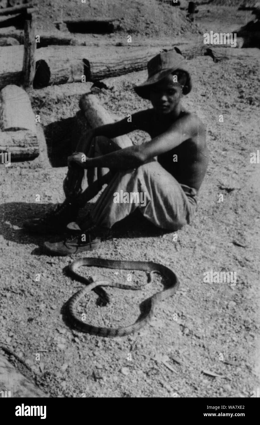 AJAXNETPHOTO. 1953-1957 (APPROX). INDO CHINA. VIETNAM. (IN-COUNTRY LOCATION UNKNOWN.) -  MAN SITTING WITH SNAKE. PHOTO:JEAN CORRE/AJAXREF:RX7 191508 231 Stock Photo
