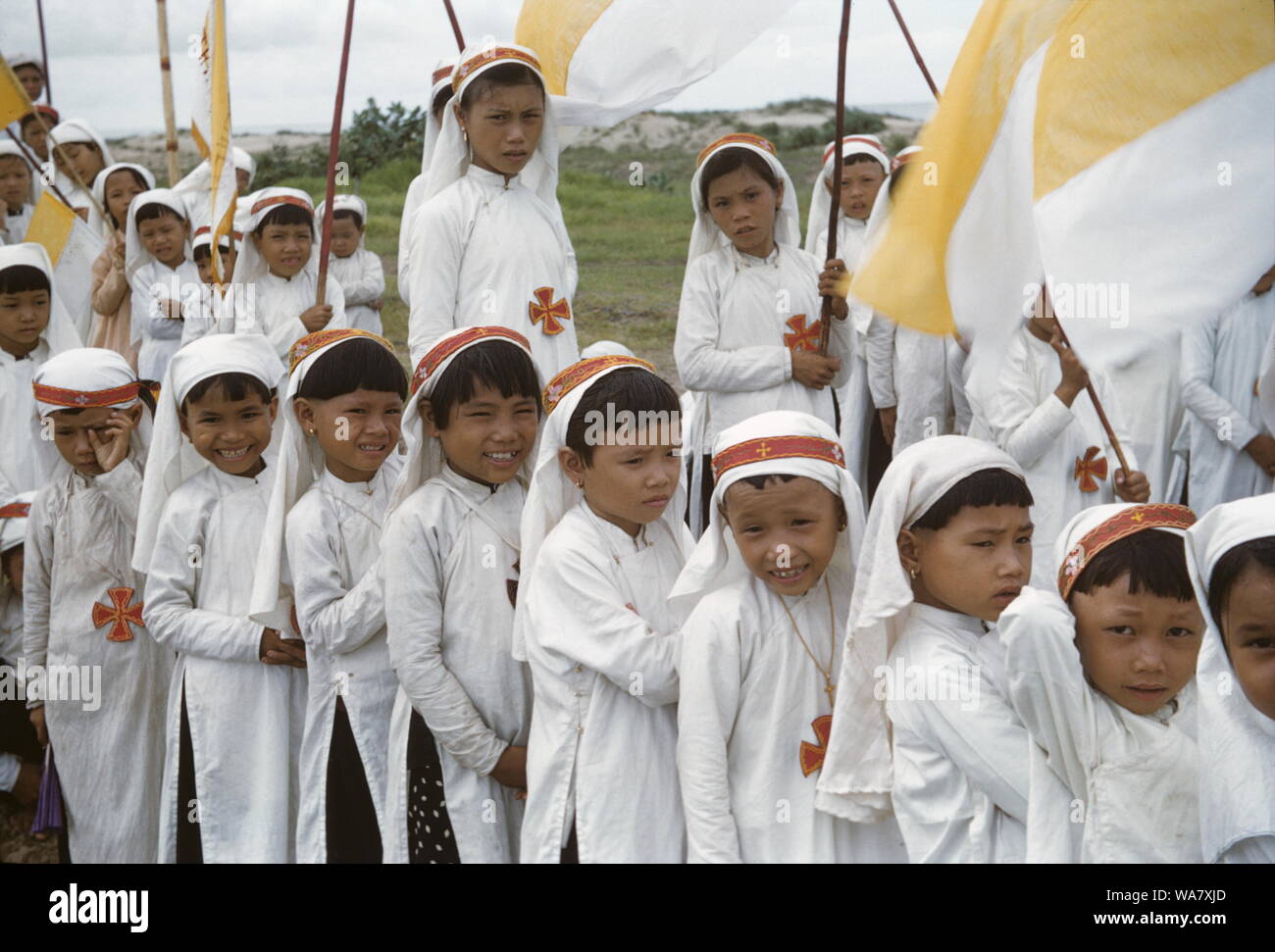 AJAXNETPHOTO. 1955 (APPROX). INDO CHINA. VIETNAM. (IN-COUNTRY LOCATION UNKNOWN.) - DRESSED IN WHITE - YOUNG CATHOLIC CHILDREN DRESSED IN WHITE ROBES AND HEADGEAR, TRADITIONAL VIETNAMESE COLOUR FOR MOURNING, IN A PROCESSION. PHOTO:JEAN CORRE/AJAXREF:1 JC1955 Stock Photo