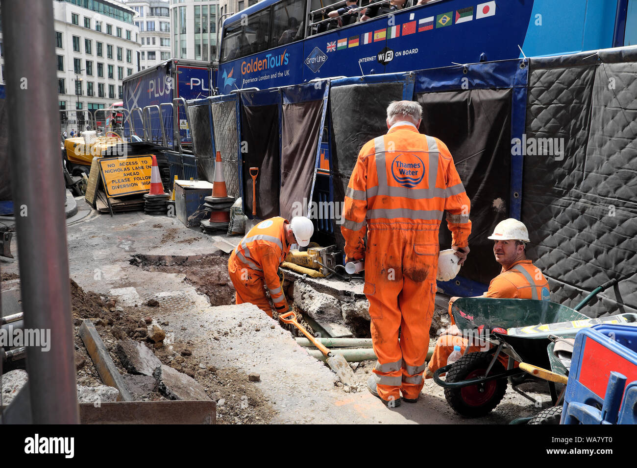 Thames Water worker and workmen digging up the road and buses on King William Street in the summer of 2019 City of London England UK  KATHY DEWITT Stock Photo