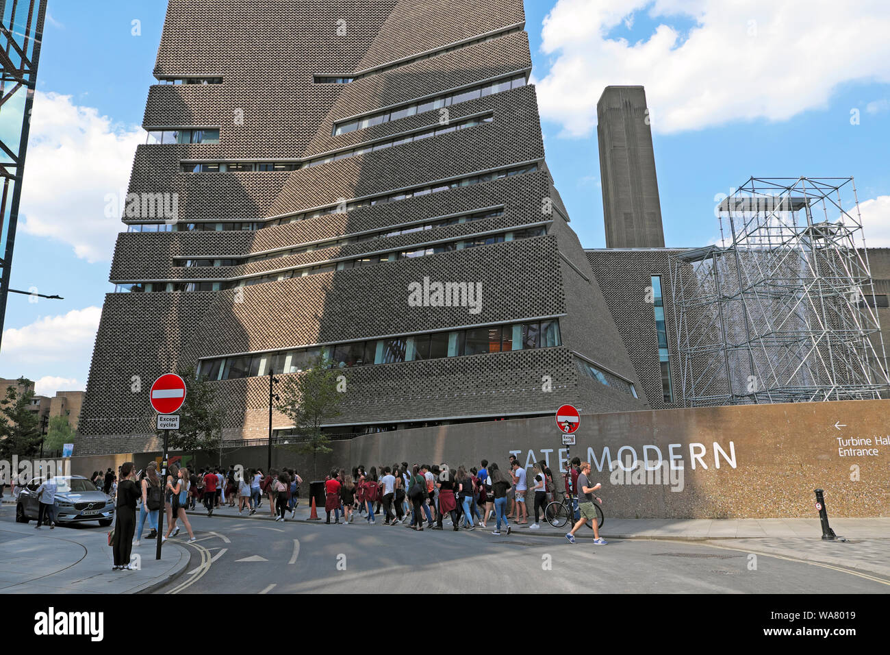 Queue of European visitors students walking in the street near the Tate Modern Art Gallery extension South London England UK  KATHY DEWITT Stock Photo