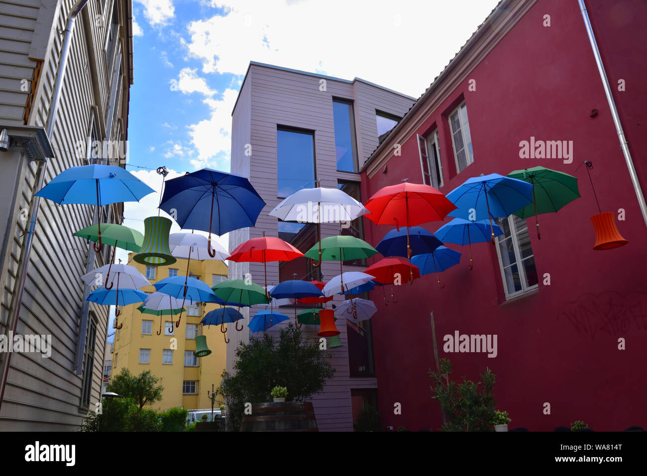 Colourful umbrellas and lanterns suspended between two buildings in Bergen, Norway. Stock Photo