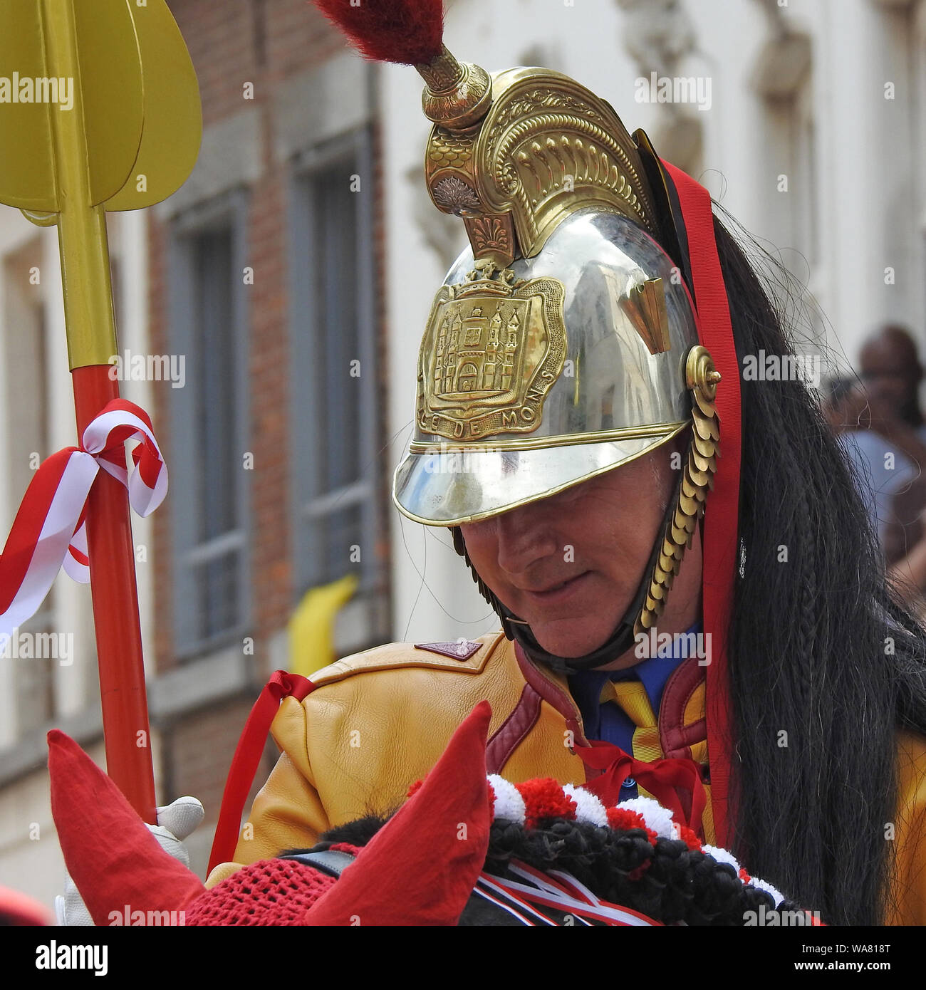 Mons, Belgium. 16 June, 2019. Participant of Ducasse and Lumeçon Game playing role of Saint George in helmet decorated with Coat of Arms of Mons Stock Photo