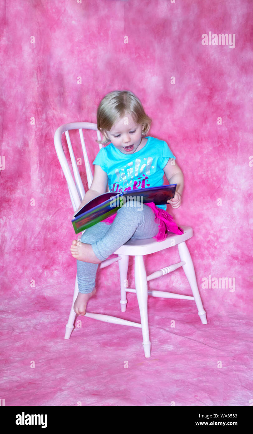 little girl enjoys a child;'s picture book Stock Photo