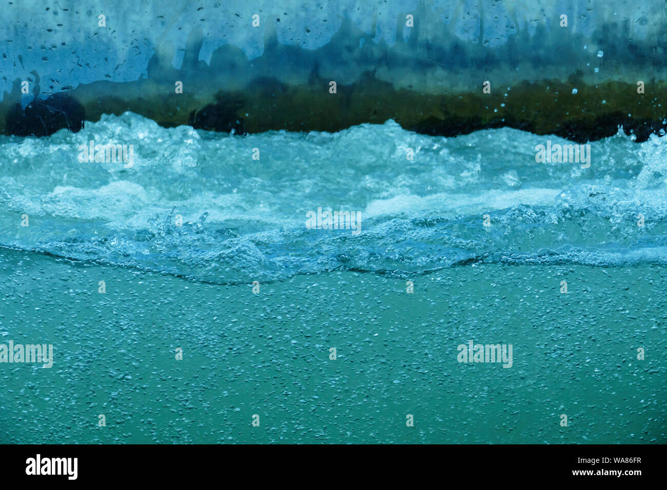 Wasser mit vielen kleinen Wasserblasen, sprudeln in türkis Stock Photo