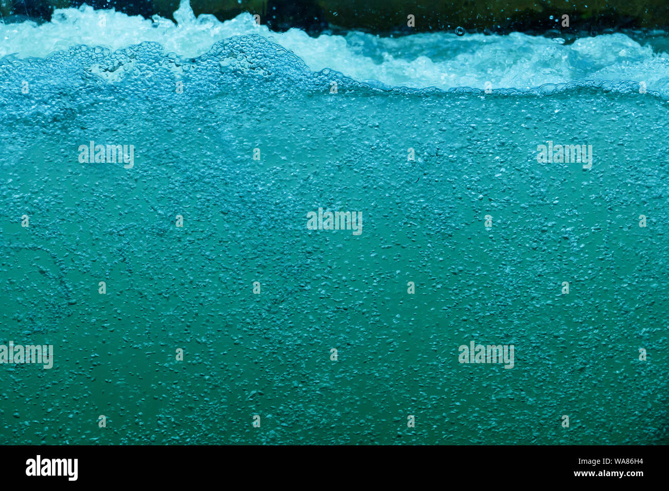 Wasser mit vielen kleinen Wasserblasen, sprudeln in türkis Stock Photo