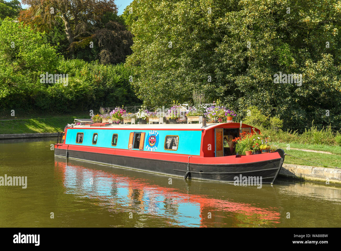 BATH, ENGLAND - JULY 2019: Coloured house boat decorated with flowers moored on the Kennet & Avon Canal near the city of Bath Stock Photo