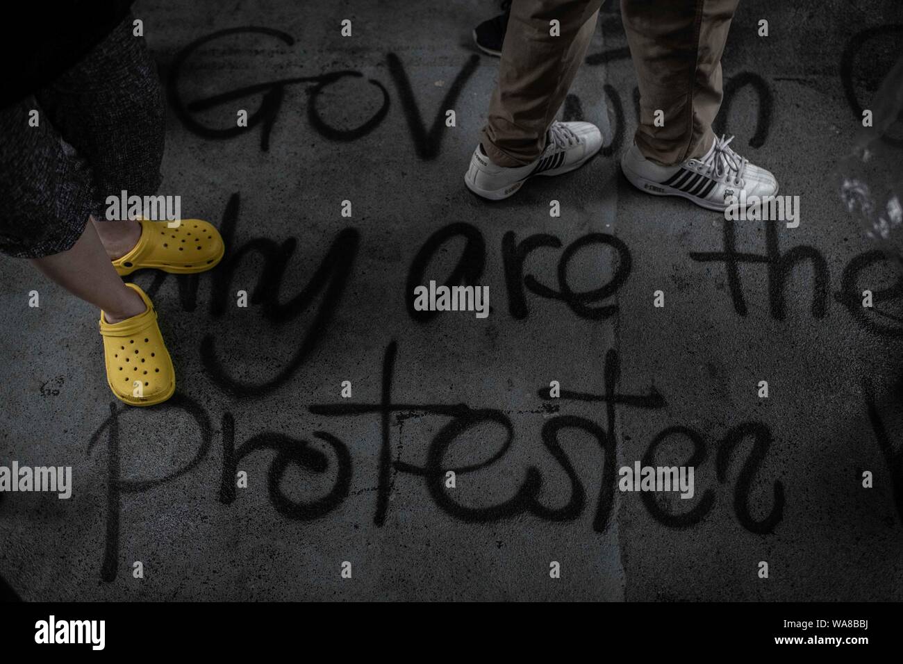 Graffiti with an anti-violence message at the footbridge floor during the demonstration.Protesters took to the streets on a rainy Sunday in a pro-democracy demonstration on Hong Kong Island, They demand the complete withdraw of the extradition bill and the government to set up an independent inquiry into the recent clashes between protesters and police - Organisers stated that this was the largest rally during the week. Stock Photo