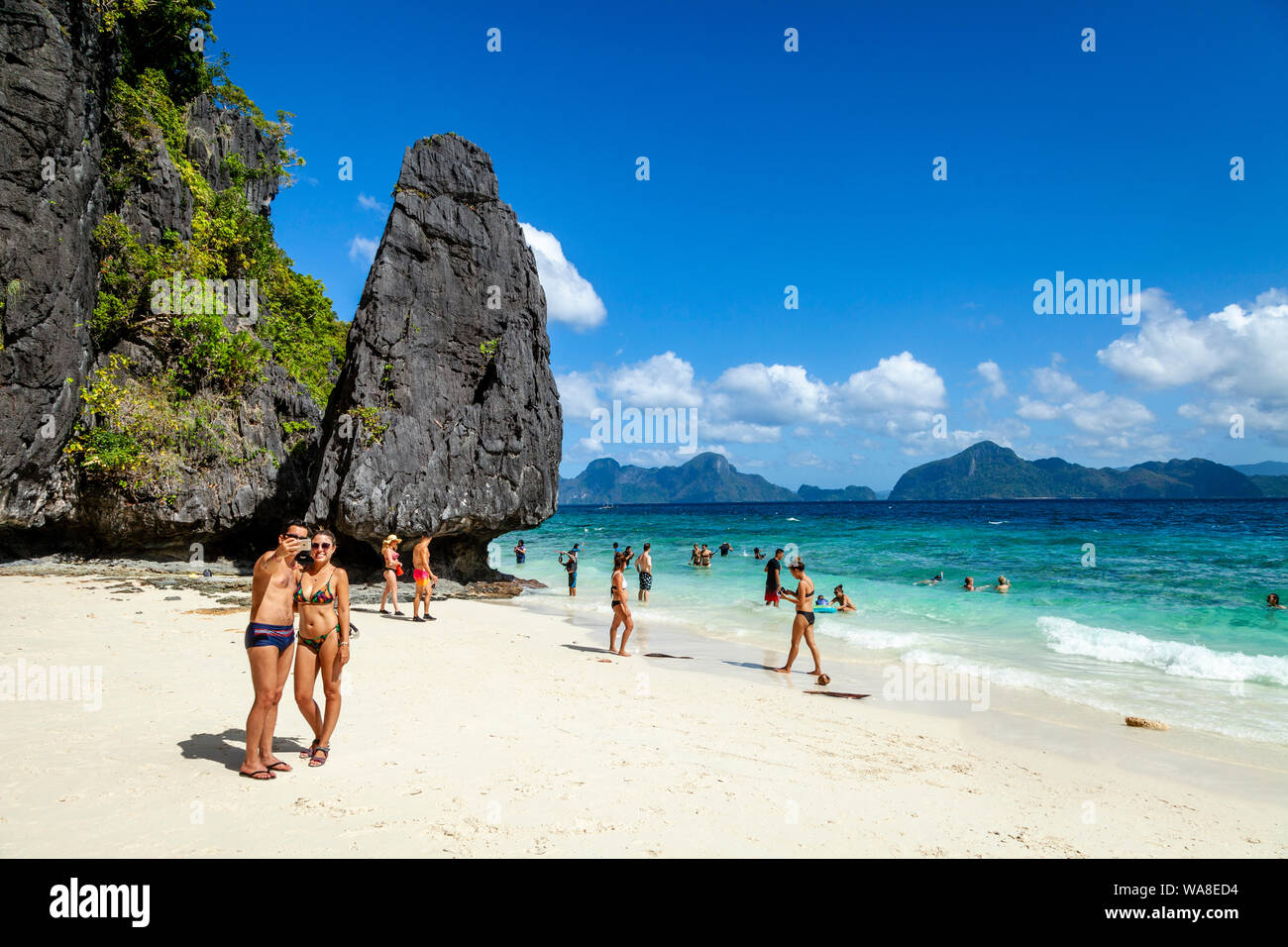 Young Tourists Pose For Photos On Entalula Beach, El Nido, Palawan, The