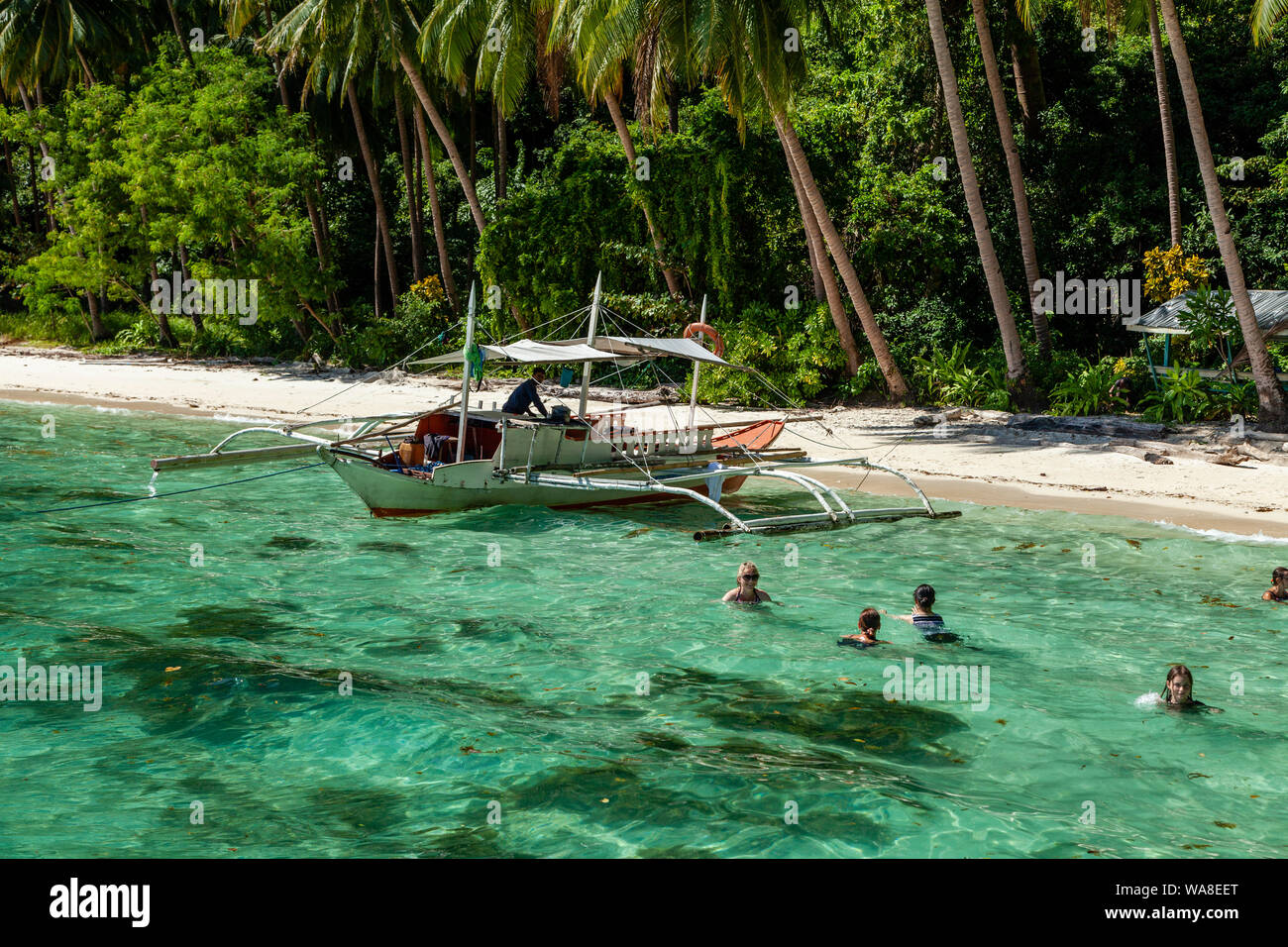 A Group Of Tourists Swimming At Pasandigan Beach, El Nido, Palawan, The