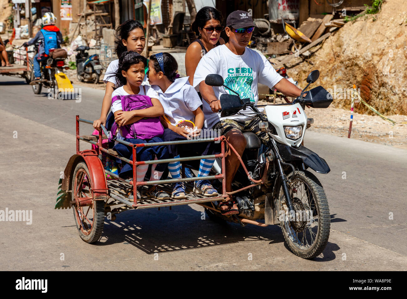 Filipino Schoolchildren Travelling To School By A Motorcycle Taxi, El Nido, Palawan Island, The Philippines Stock Photo