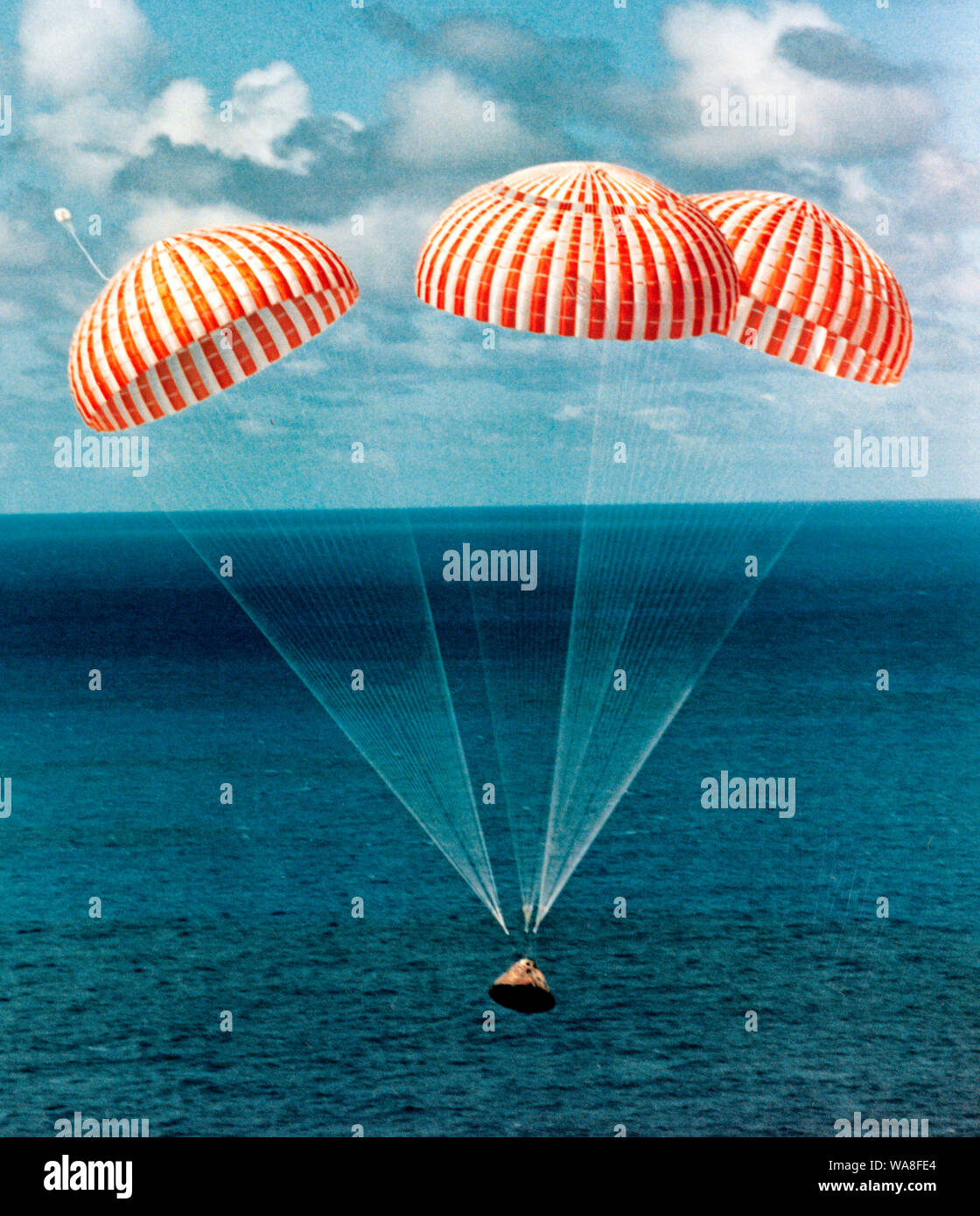 The Apollo 14 Command Module (CM), with astronauts Alan B. Shepard Jr., commander; Stuart A. Roosa, command module pilot; and Edgar D. Mitchell, lunar module pilot, aboard, approaches touchdown in the South Pacific Ocean to successfully end a 10-day lunar landing mission. The splashdown occurred at 3:04:39 p.m. (CST), Feb. 9, 1971, approximately 765 nautical miles south of American Samoa. The three crew men were flown by helicopter to the USS New Orleans prime recovery ship. Stock Photo