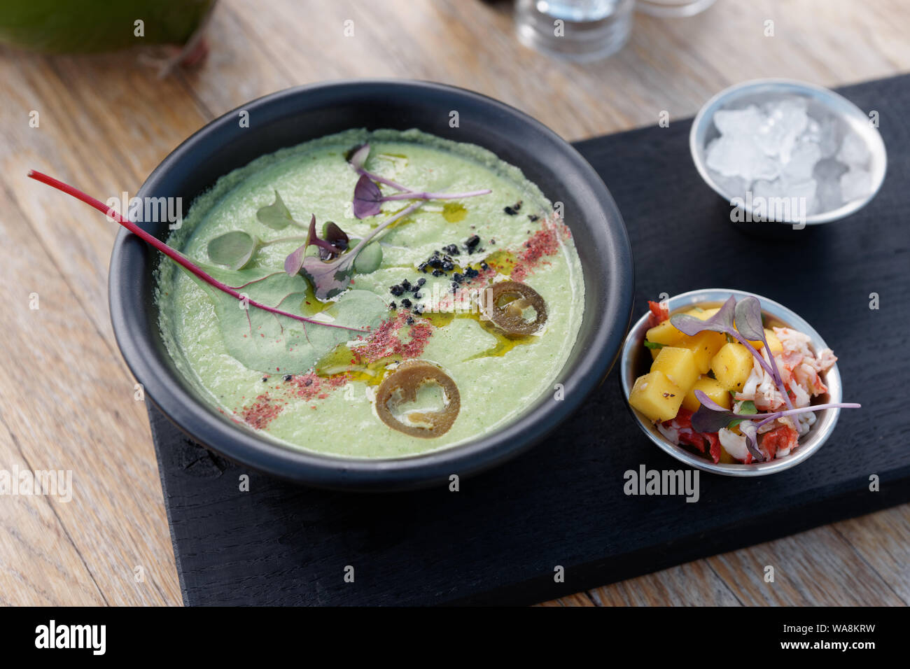 Ice cold summer vegetable soup with spices and mangold leaf, crab and