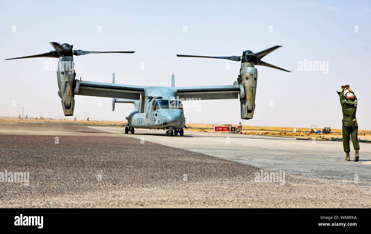 A U.S. Marine with Marine Medium Tiltrotor Squadron (VMM) 364, attached to Special Purpose Marine Air-Ground Task Force-Crisis Response-Central Command, guides a MV-22 Osprey during an Emergency Response Exercise in Kuwait, Aug. 16, 2019. A Marine Air Ground Task Force is specifically designed to be capable of deploying aviation, ground, and logistics forces forward at a moment’s notice. (U.S. Marine Corps photo by Sgt. Kyle C. Talbot) Stock Photo