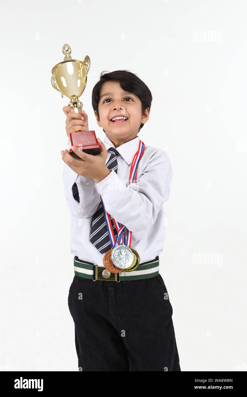 Schoolboy showing a trophy and smiling Stock Photo