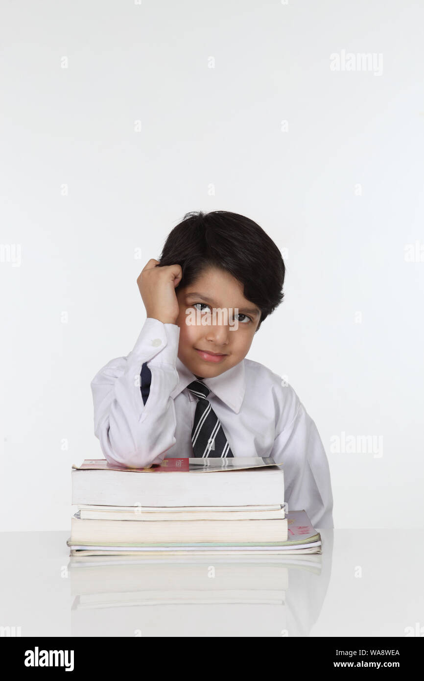 Schoolboy sitting with books in a classroom Stock Photo - Alamy