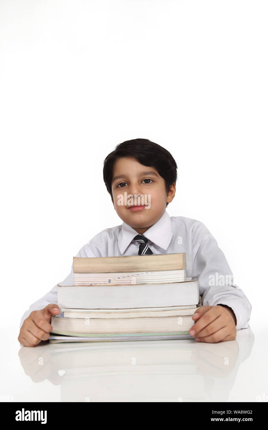 Schoolboy sitting with books in a classroom Stock Photo - Alamy