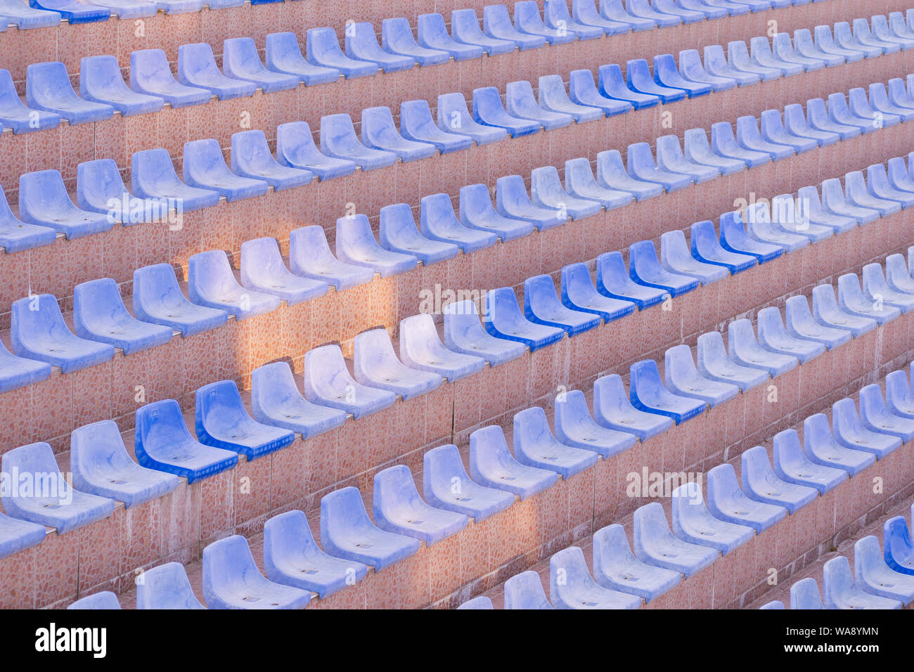 Detailed, geometric view of empty seats. Light pastel filter. Fine art or wallpaper. Stock Photo
