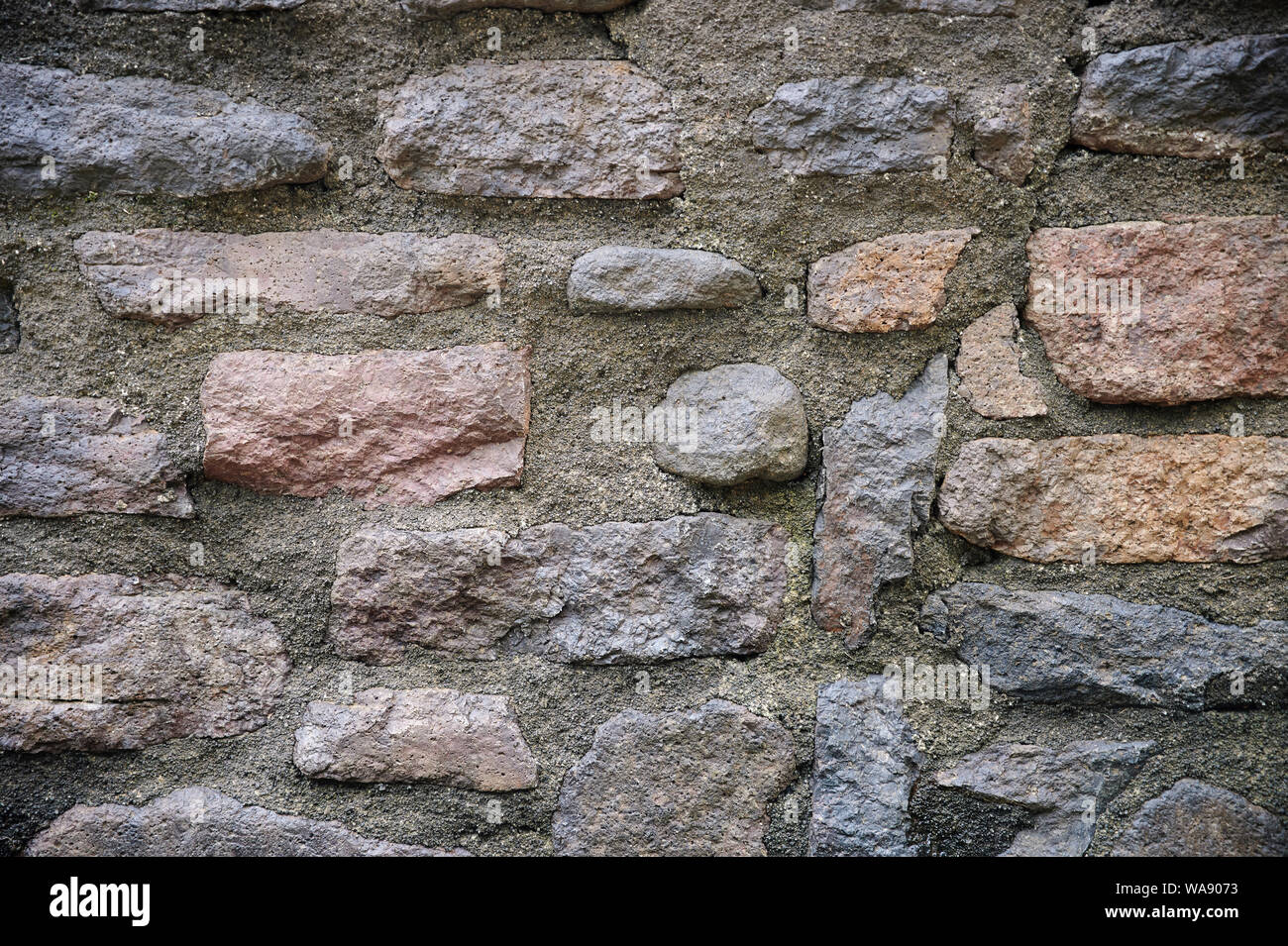 Stone bricks wall with grey cement close up view Stock Photo