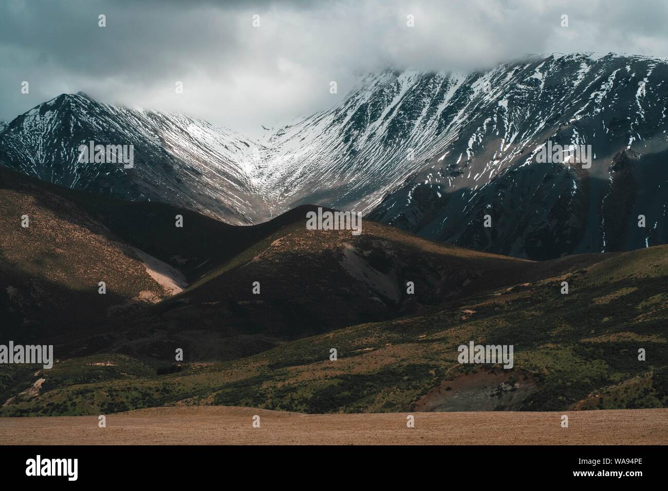 Beautiful Shot Of Snowy Rocky Mountains And Hills Under A Misty Cloudy Sky Stock Photo Alamy