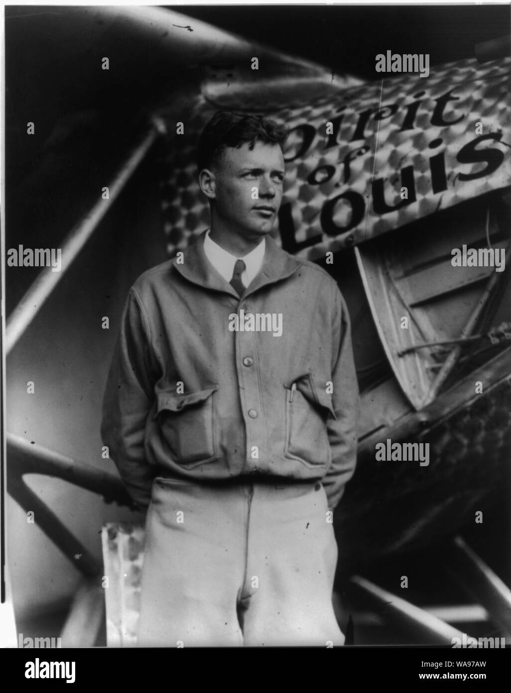 Charles Lindbergh standing beside the Spirit of St. Louis aircraft, symbolizing the historic moment of his transatlantic flight.