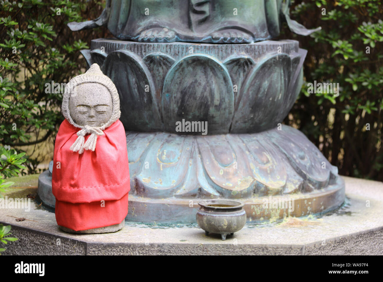Stone statue of smiling Jizo (Jizo Bosatsu) in a knitted hat, Kobe
