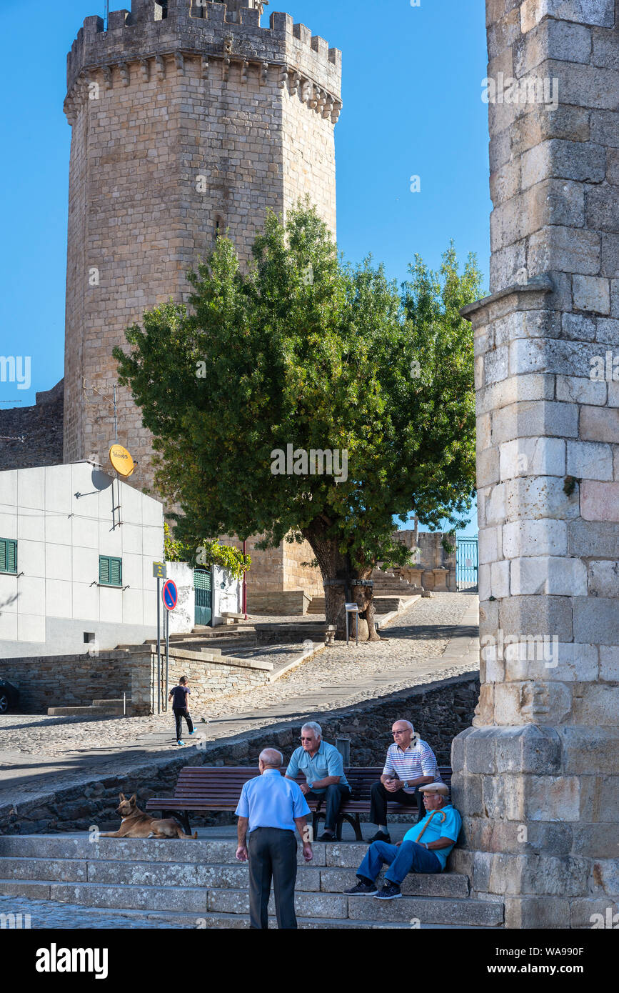 Local people chating by the church in Freixo de Espada à Cinta, with the castle in the background, in the Trás-os-Montes e Alto Douro Province of Nort Stock Photo