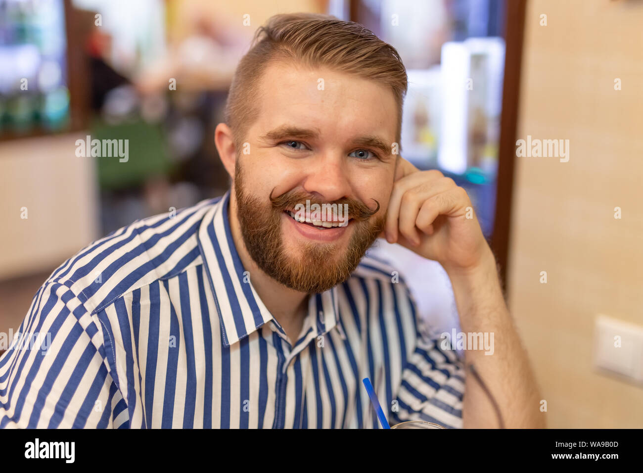 Cute Positive Young Hipster Guy With A Mustache And Beard Smiling