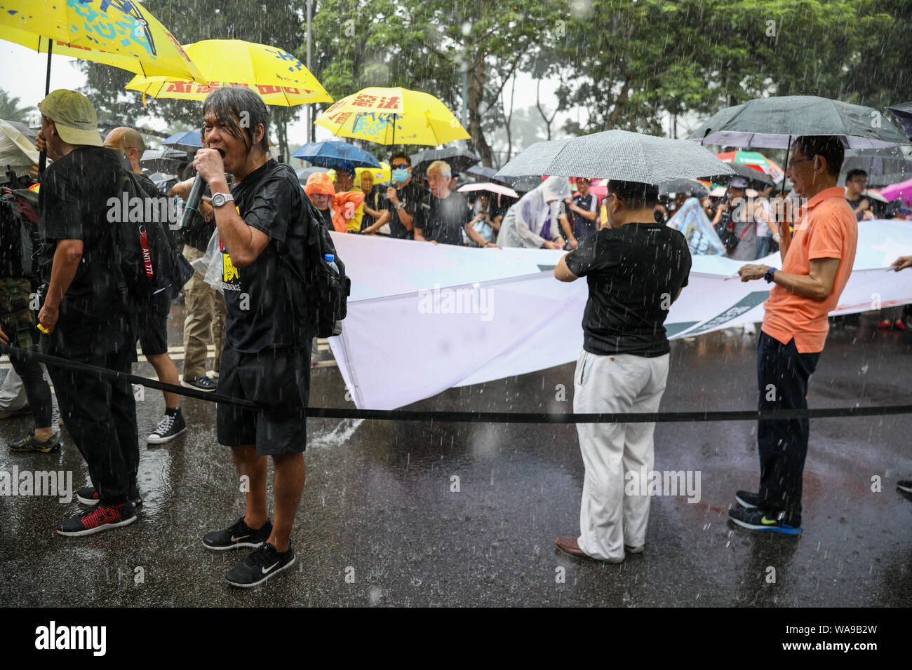 Hong Kong. 18th Aug, 2000. Protesters including former Legislative Council member Leung Kwok-hung 'Longhair' began an unauthorized march during torrential rain outside Victoria Park where a rally organised by the Civil Human Rights Front was being held which organizers claim more than 1.7 million people attended. 18th August 2019. Credit: David Coulson/Alamy Live News Stock Photo