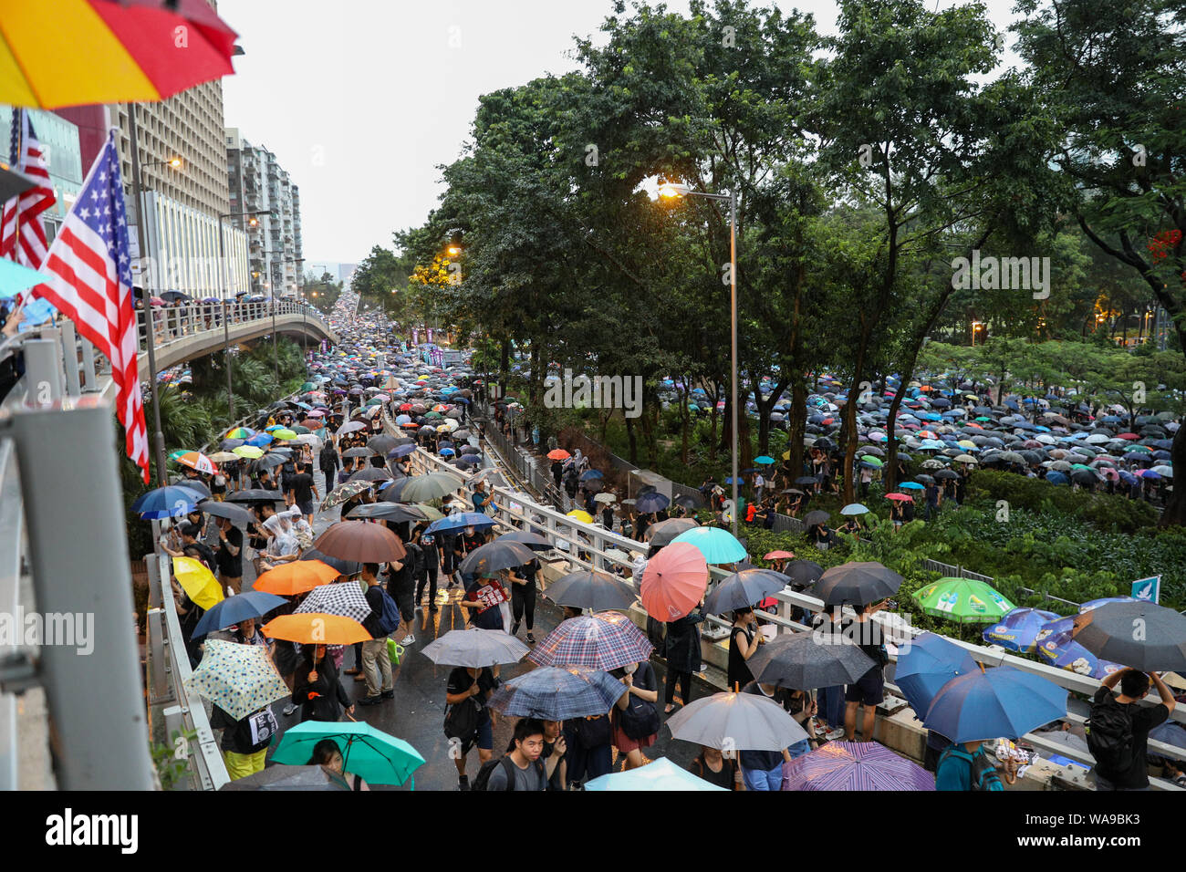 Hong Kong. 18th Aug, 2000. Huge number of protesters holding umbrellas on an unauthorized march during heavy rain when marching from Victoria Park where a rally organised by the Civil Human Rights Front was being held which organizers claim more than 1.7 million people attended.  Some protesters held flags from the USA. 18th August 2019 Credit: David Coulson/Alamy Live News Stock Photo