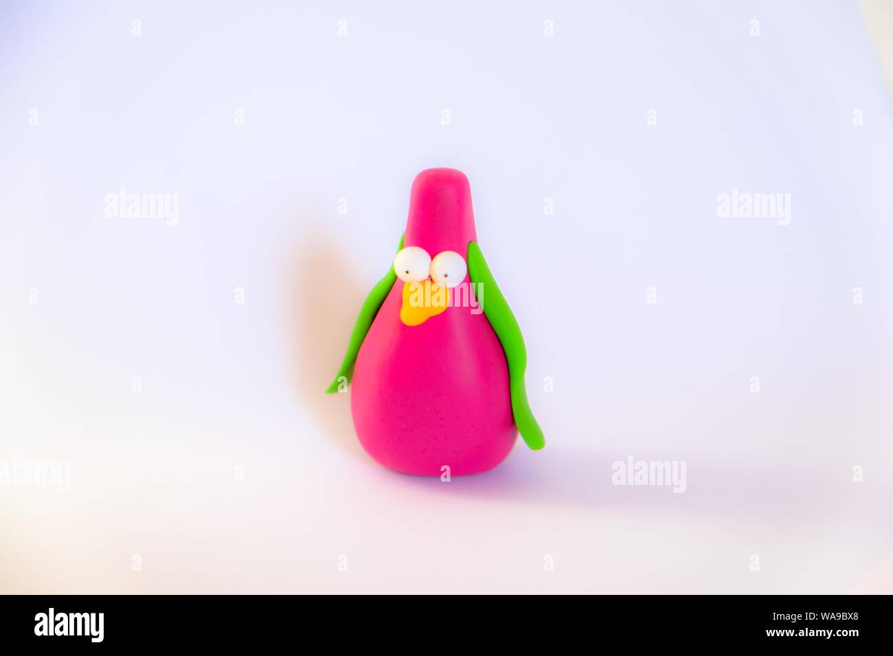 Closeup shot of a toy made out of purple and green clay with a white background Stock Photo
