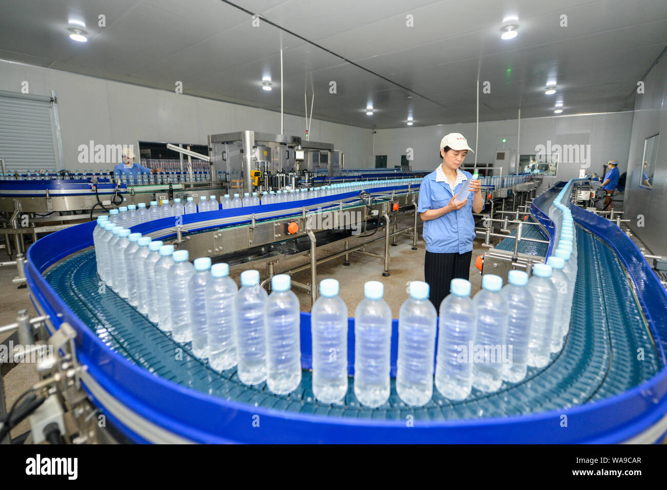 Chinese workers produce bottles of mineral water on an assembly line at a  plant in Changxing county, Huzhou city, east China's Zhejiang province, 28  J Stock Photo - Alamy