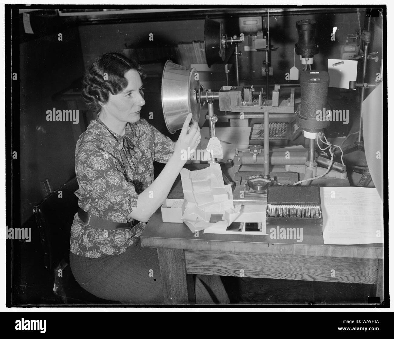 Checks railroad signal glasses for government. Washington, D.C., Sept. 29. Red should be read and orange should be orange and never should the colors in railroad signal glasses be so near alike as to confuse a trainman. The Government, through Mrs. Geraldine W. Haupt, Color Expert of the National Bureau of Standards, tests all railroad signal glasses to determine if the color value is true and also to see that they conform to certain specifications. 9/29/37 Stock Photo