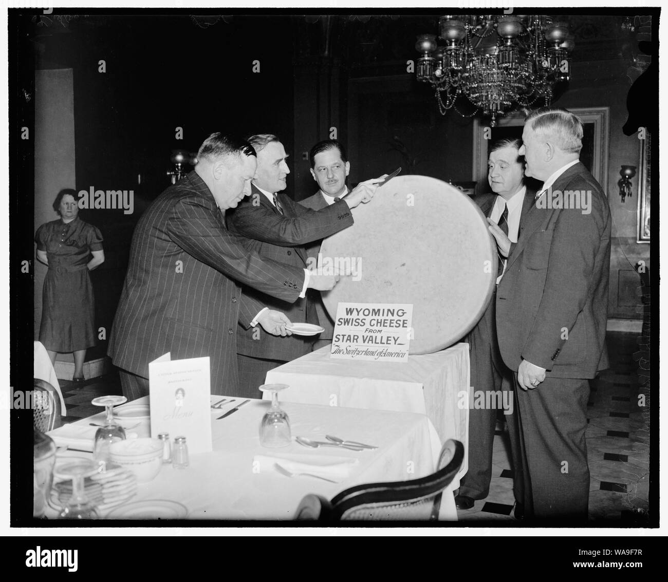 Cheese party for statesmen. Washington, D.C., June 4. The famous swiss cheese from The Star Valley of Wyoming was the piece of resistance at the Capitol today for the members of Congress and other high government officials hailing from the state. The cheese weighed 250 pounds. Left to right: Rep. Paul R. Greener; Sen. Joseph D. O'Mahoney; Thurman Arnold, Assistant Attorney General; Fred W. Johnson, Commisioner, General Land office; and Senator H.H. Schwartz, 6/4/38 Stock Photo
