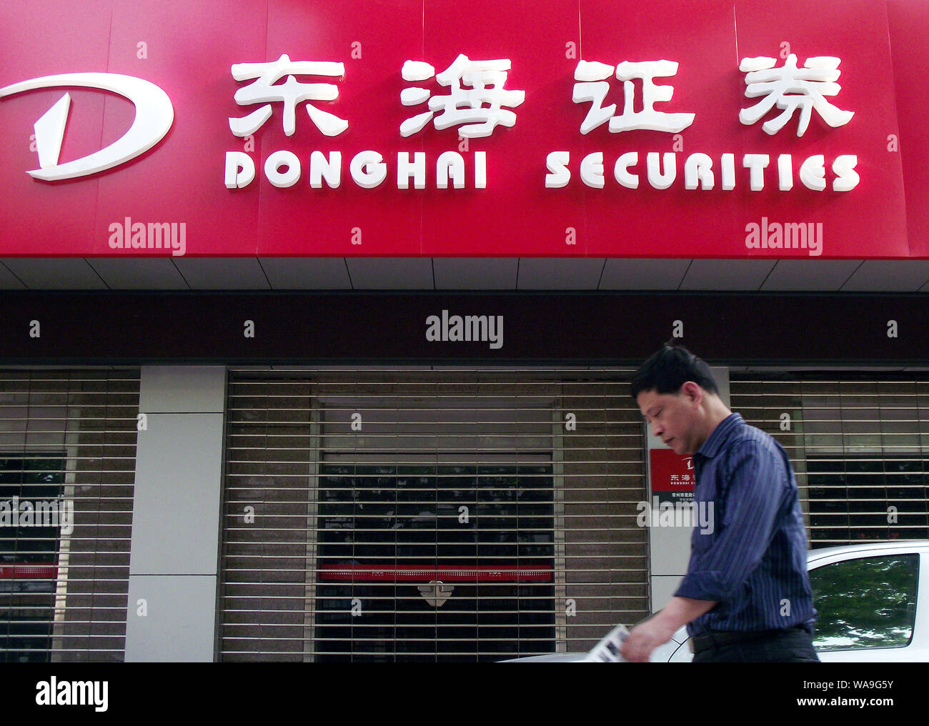 --FILE--A pedestrian walks past a branch of Donghai Securities Co. Ltd. in Nanjing city, east China's Jiangsu province, 5 May 2013.   Donghai Securiti Stock Photo