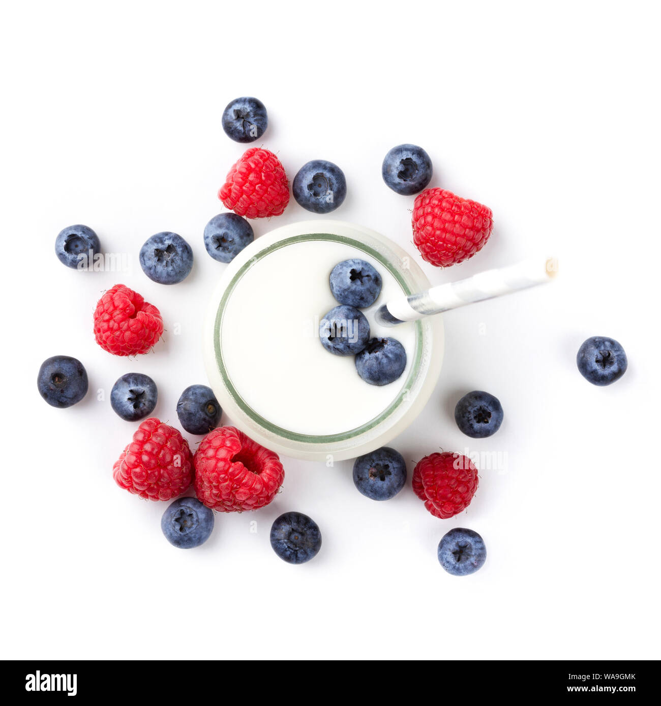 Glass of greek yogurt and fresh raspberries and blueberries isolated on white background. Top view Stock Photo