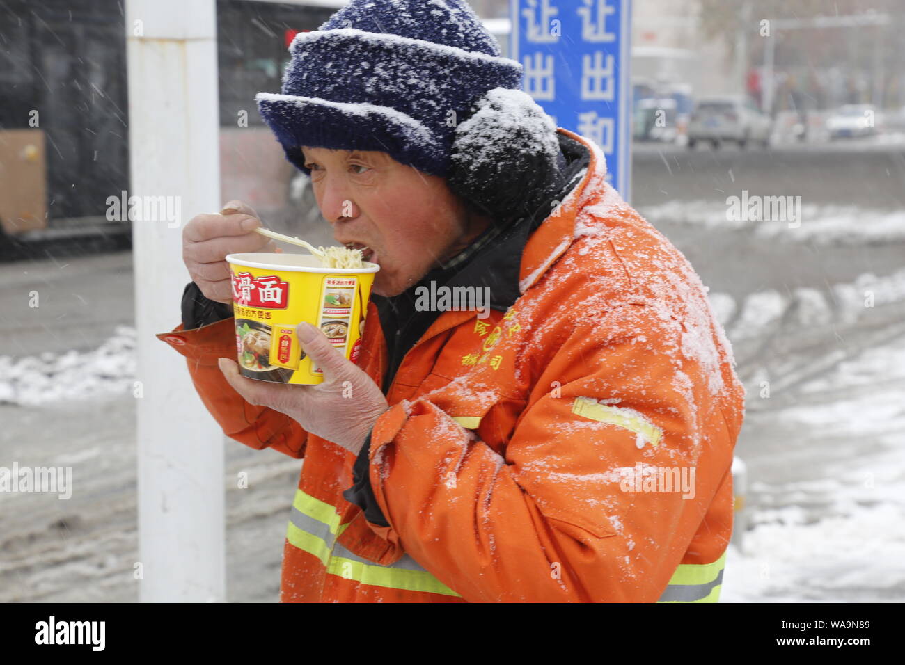 -FILE-A sanitation worker eats instant noodles given by university students of Henan Agricultural University in Zhengzhou, central China's Henan provi Stock Photo