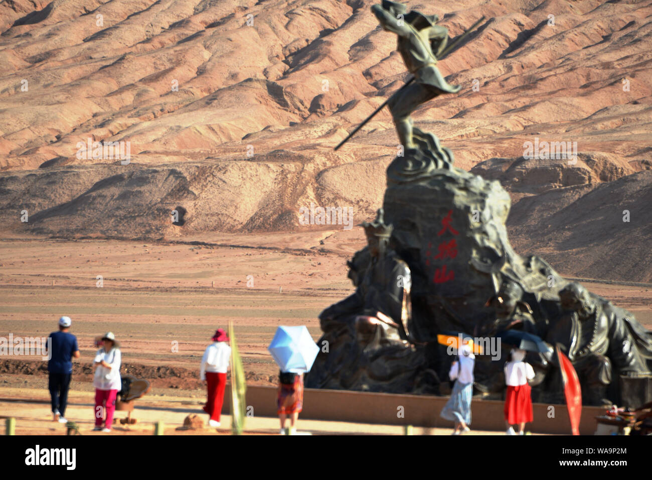 Tourists pose for photos with the landmark sculpture at the foot of the