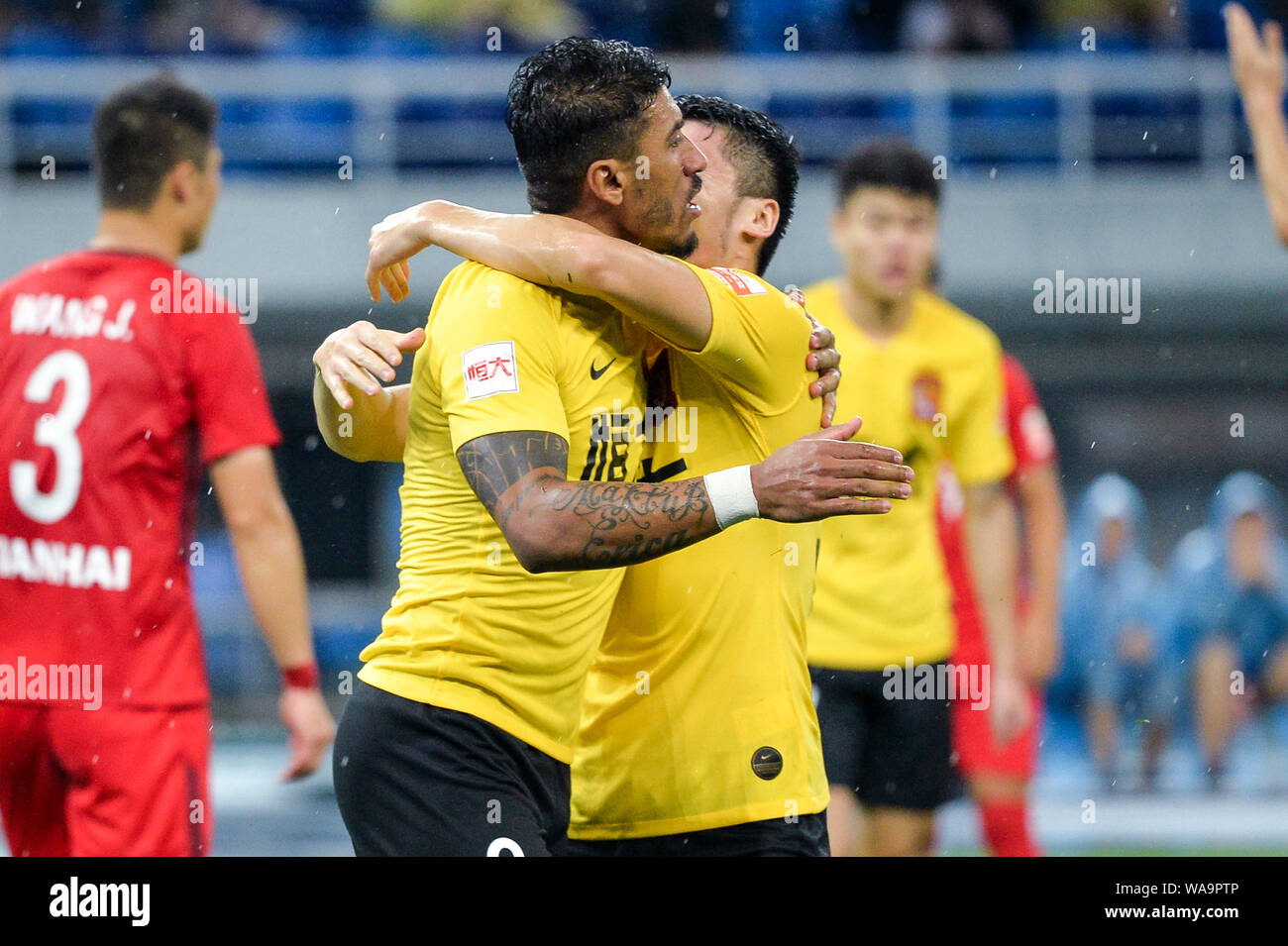 Brazilian football player Paulinho, left, of Guangzhou Evergrande Taobao celebrates with his teammate after scoring against Tianjin Tianhai in their 1 Stock Photo