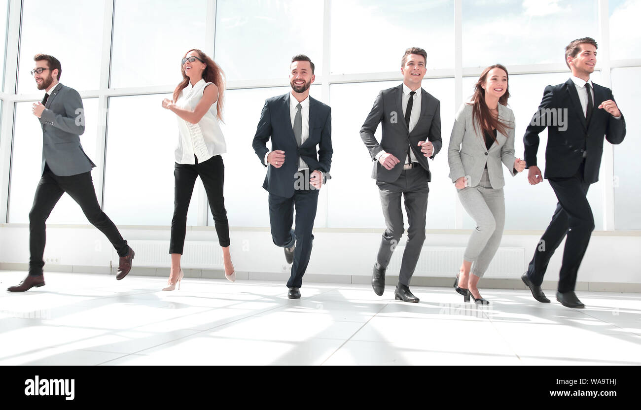 successful business team running in the office hall Stock Photo - Alamy
